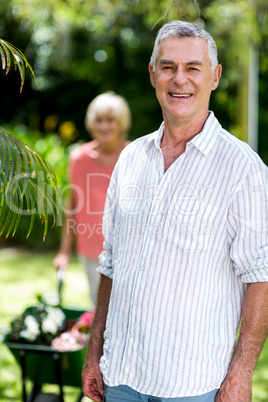 Senior man standing against woman at yard