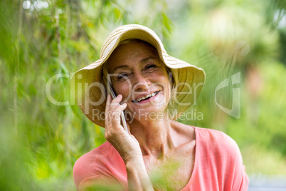 Senior woman talking on phone in yard