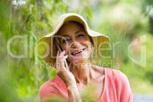 Senior woman talking on phone in yard