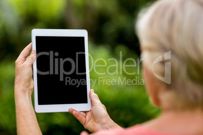 Woman holding tablet at yard