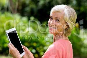 Senior woman with tablet at yard