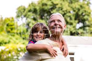Grandmother carrying grandson at yard