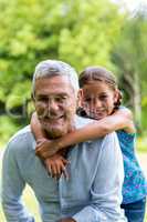 Smiling grandfather with grandaughter at yard