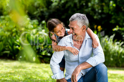 Grandfather and grandaughter playing at yard