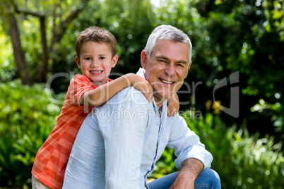 Smiling garndfather with grandson at yard