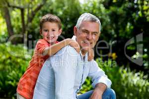 Smiling garndfather with grandson at yard