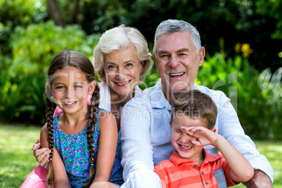 Children with grandparents sitting at yard