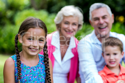 Girl with brother and grandparents at yard