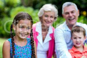 Girl with brother and grandparents at yard