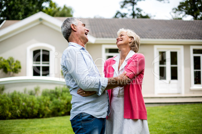 Happy senior couple hugging in yard