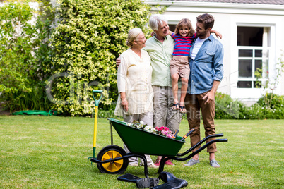 Father and grandfather carrying son at yard