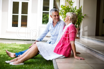Senior couple sitting on steps outside house at yard