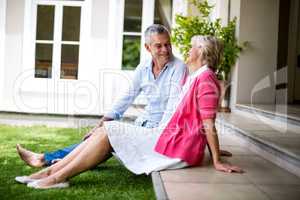 Senior couple sitting on steps outside house at yard