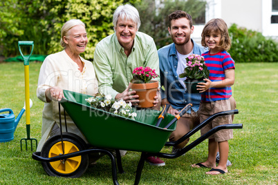 Multi generation family with gardening tools in yard
