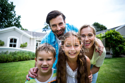 Portrait of family standing outside house in yard