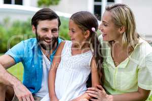 Mother and daughter looking at father in yard