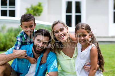 Portrait of happy family sitting at yard