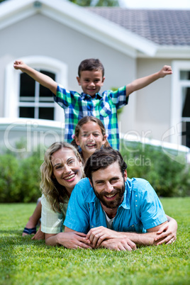 Happy family lying on top of each other in yard
