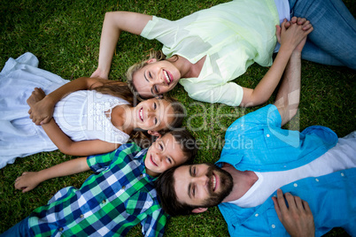 Smiling family lying on grass at yard