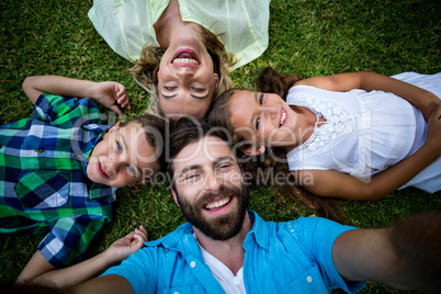 Cheerful family lying on grass in yard