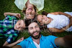 Cheerful family lying on grass in yard