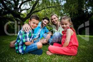 Happy family siting on grass in yard