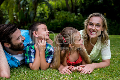 Father and children looking at mother in yard