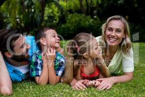 Father and children looking at mother in yard