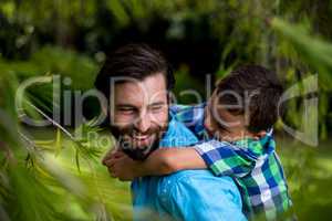 Happy father carrying son at yard