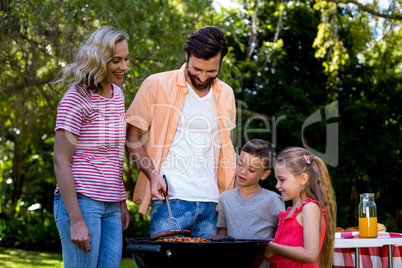 Family grilled food on barbecue at yard
