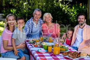 Multi-generation family enjoying breakfast in yard