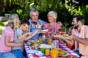 Multi- generation family offering food at breakfast