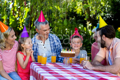 Family looking at birthday boy during celebration