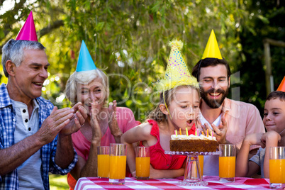 Family celebrating birthday at table in yard