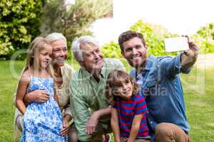 Happy father taking selfie with family in yard