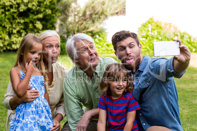 Happy father taking selfie with family in yard