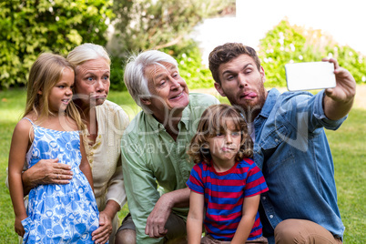 Happy father taking selfie with family in yard