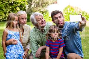 Happy father taking selfie with family in yard