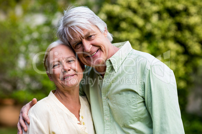 Smiling senior couple standing in yard