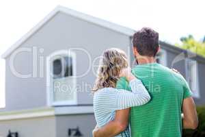 Couple standing against house