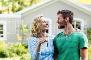 Couple looking each other while holding keys