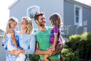 Parents carrying children in yard