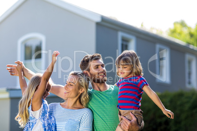 Parents carrying children with arms raised