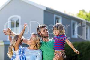 Parents carrying children with arms raised