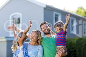 Happy parents carrying children with arms raised