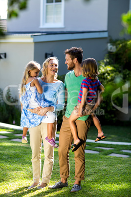 Parents carrying children in yard