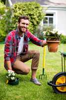 Happy gardener holding potted plants in yard