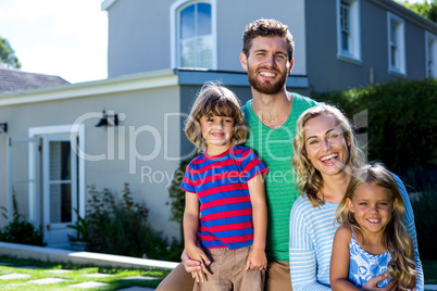 Cheerful family against house