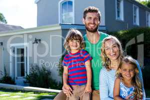 Cheerful family against house
