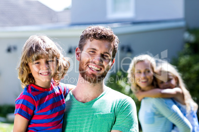 Happy family standing against house